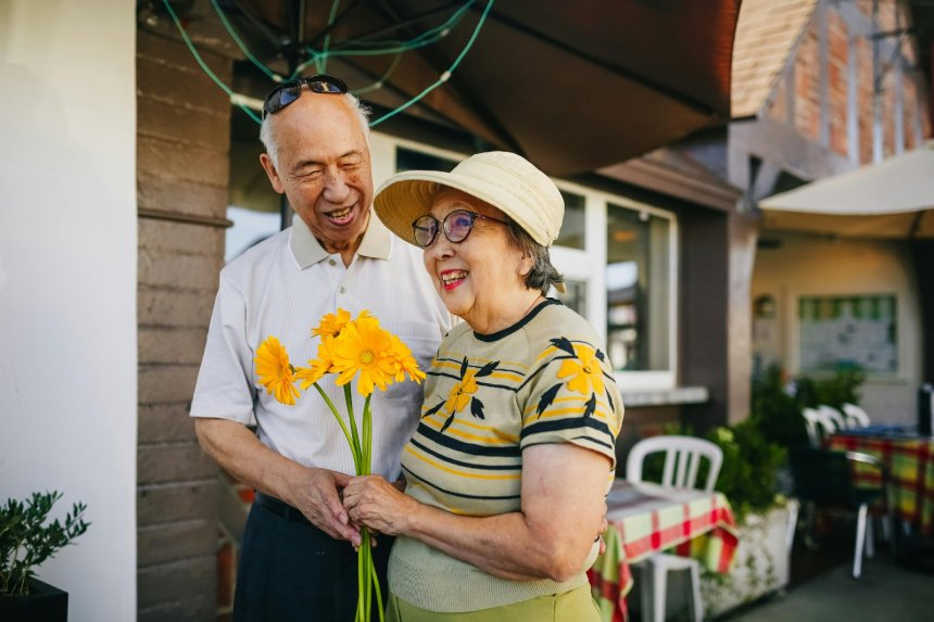 happy old wife as husband gives her flowers