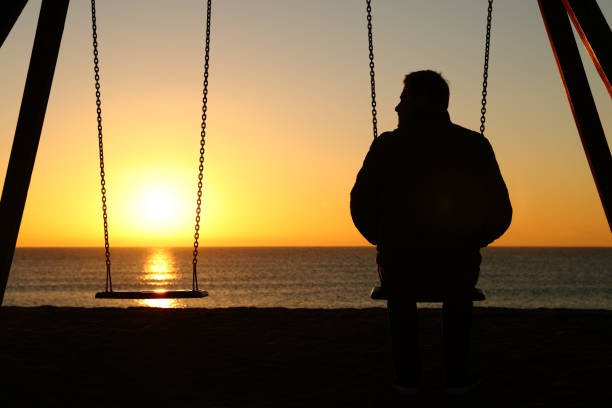 lonely man sitting alone on the swings